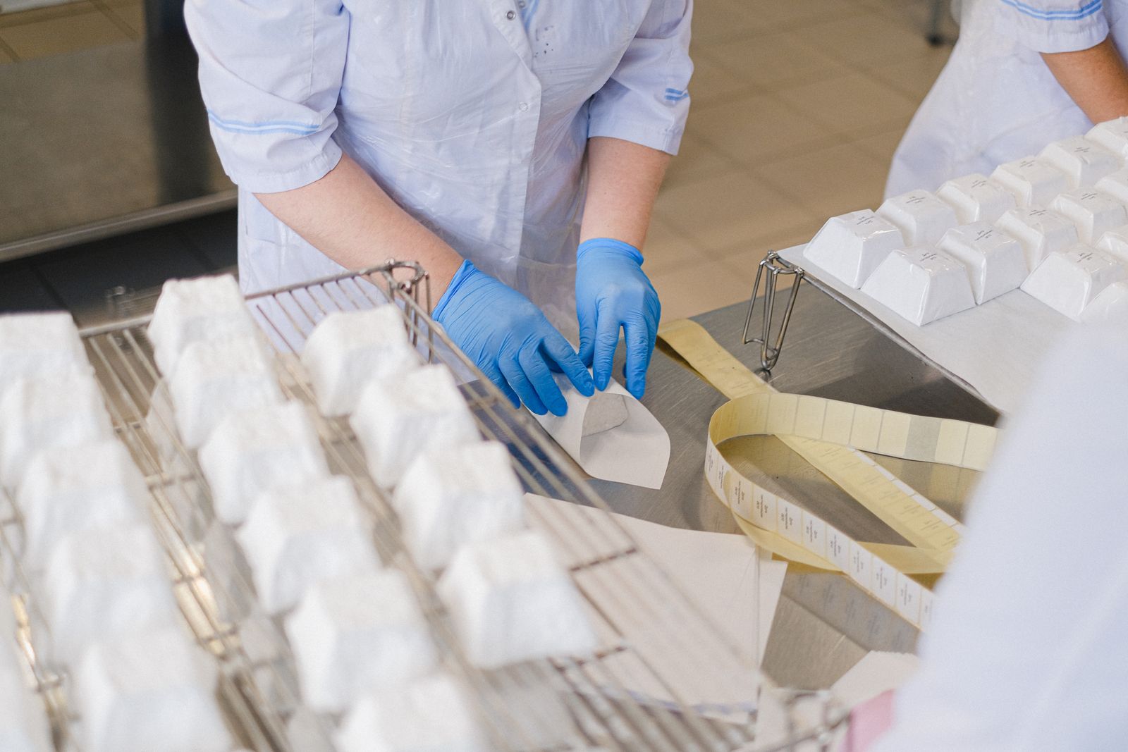 Gloved operator packaging cheese blocks